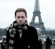 A Parisian scowls in front of the Eiffel Tower.